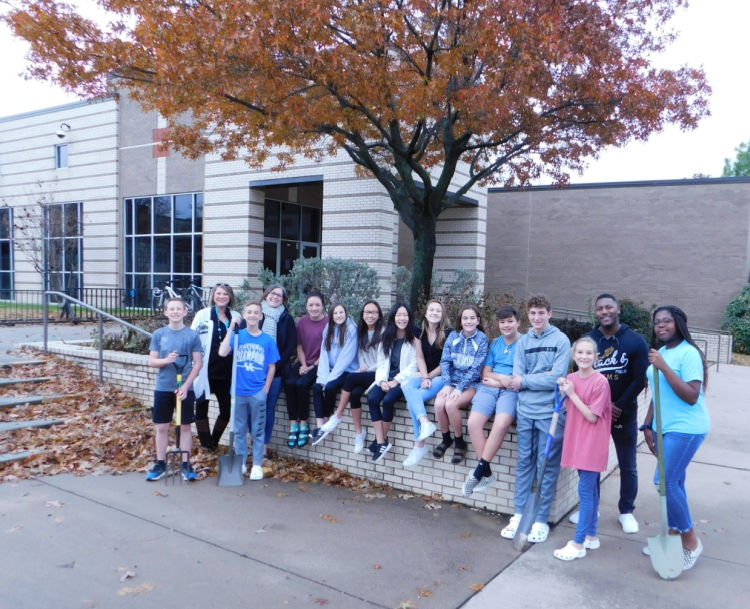 team of students outside front entrance of school