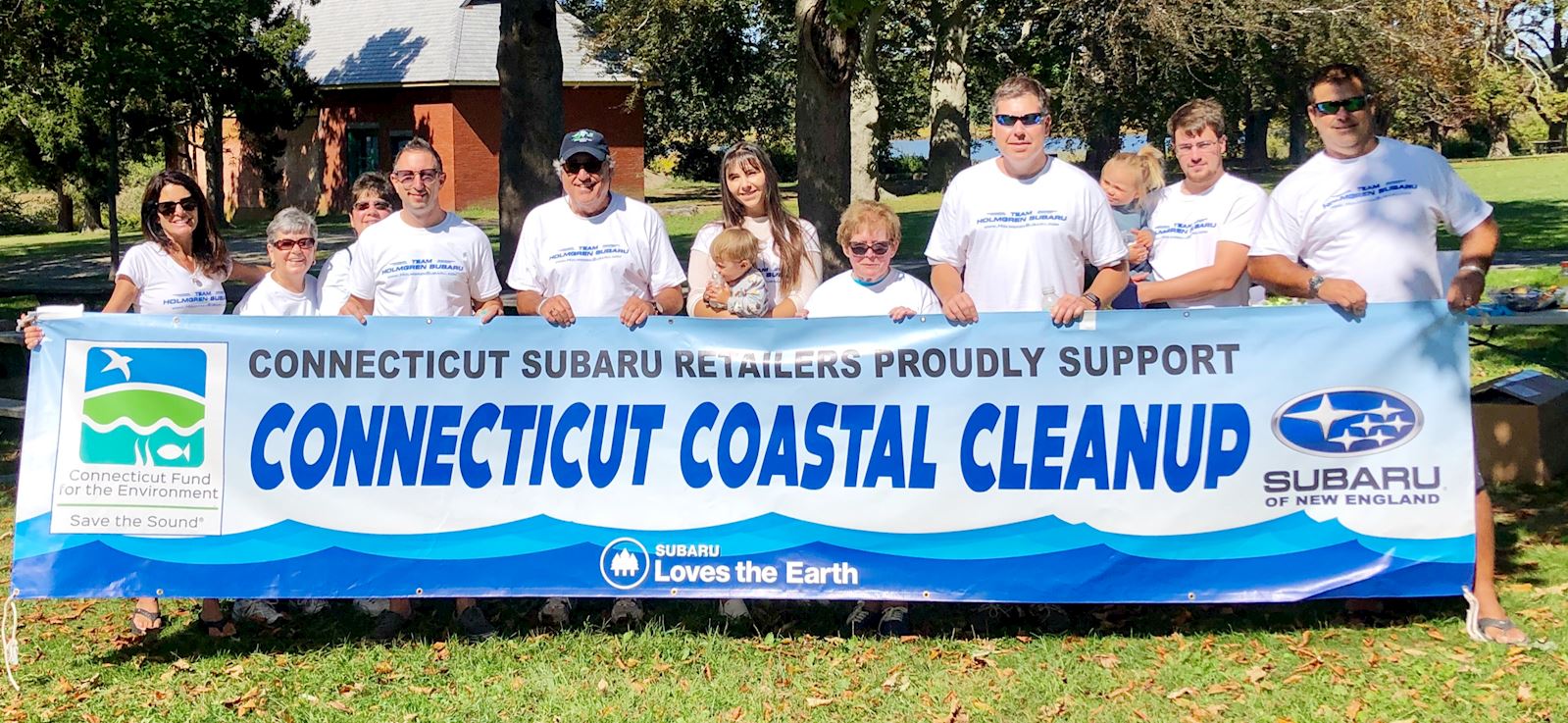 group holding banner promoting Connecticut coast trash cleanup
