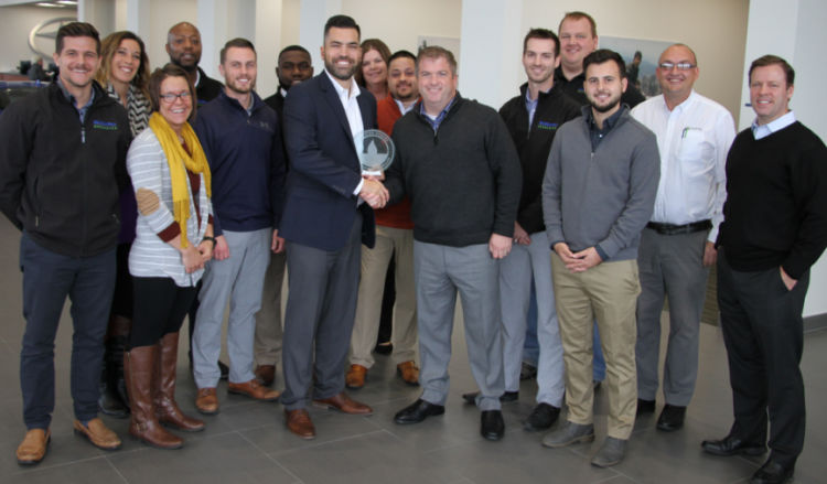 Employees at Subaru of Rochester receiving trophy